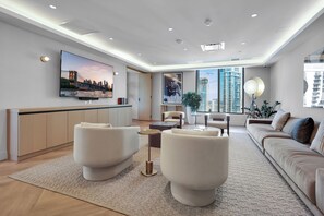 A modern living room with a flat-screen TV, comfortable seating, and large windows offering city views. - 501 First Luxury 1 BR + Den & 2 Baths Rooftop Pool & GYM 502 (Miami)