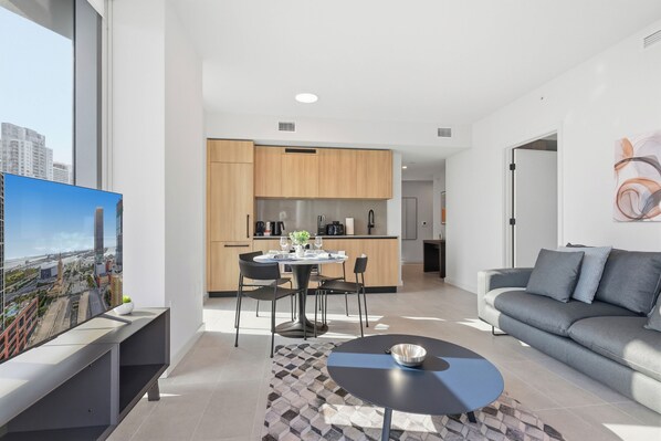 Ein modernes Apartment mit Essbereich, Küche und Wohnzimmer.
