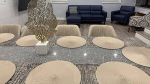 A modern living room with a grey marble table, beige woven placemats, a decorative tree sculpture, and a blue sofa set. - Sunset cruiser close to Redington Beach (Seminole)