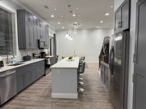 A modern kitchen with grey cabinets, a central island, stainless steel appliances, and pendant lighting. - Sunset cruiser close to Redington Beach (Seminole)
