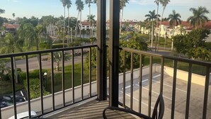 A balcony with a view of a street lined with palm trees and buildings. - Close to everything! 1bdr in St. Pete beach (St. Petersburg)