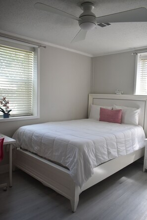 A bedroom with a bed, a nightstand, a desk, and a ceiling fan. - 2-Bed Home Near Masters in Augusta, GA (Augusta)