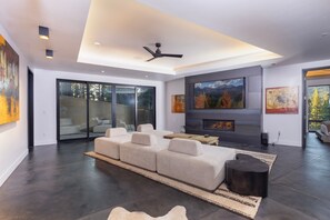 A modern living room with a sectional sofa, a fireplace, and artwork on the walls.