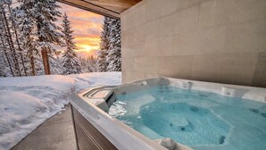 A hot tub with a view of snow-covered trees and a sunset. - Steps to slopes; 7,000 sq feet of Luxury, golf simulator, hot tub! (Copper Mountain)