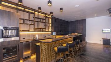 A modern kitchen with a bar area, built-in appliances, and a seating arrangement.