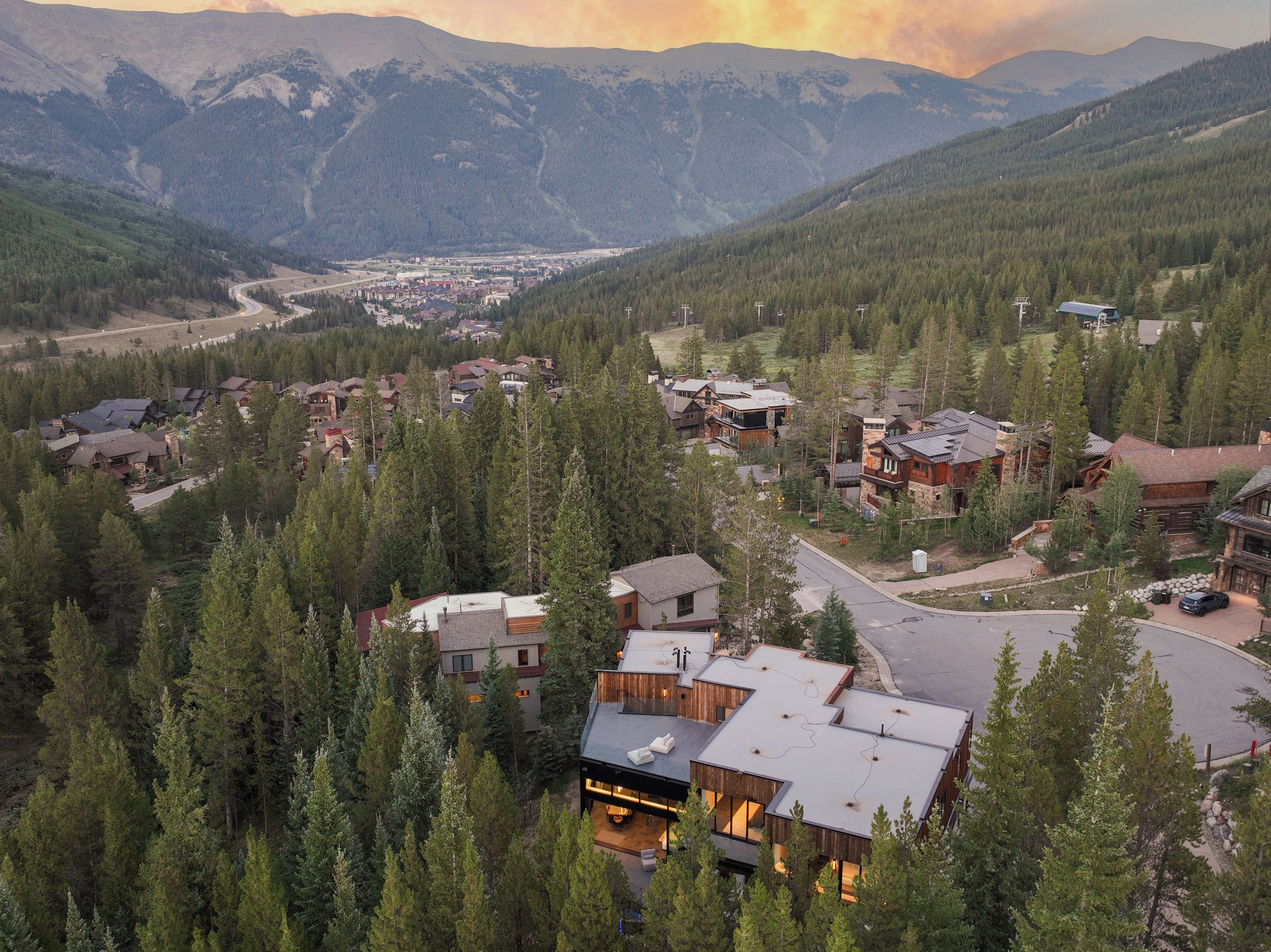 A mountainous town with modern houses surrounded by dense forests.