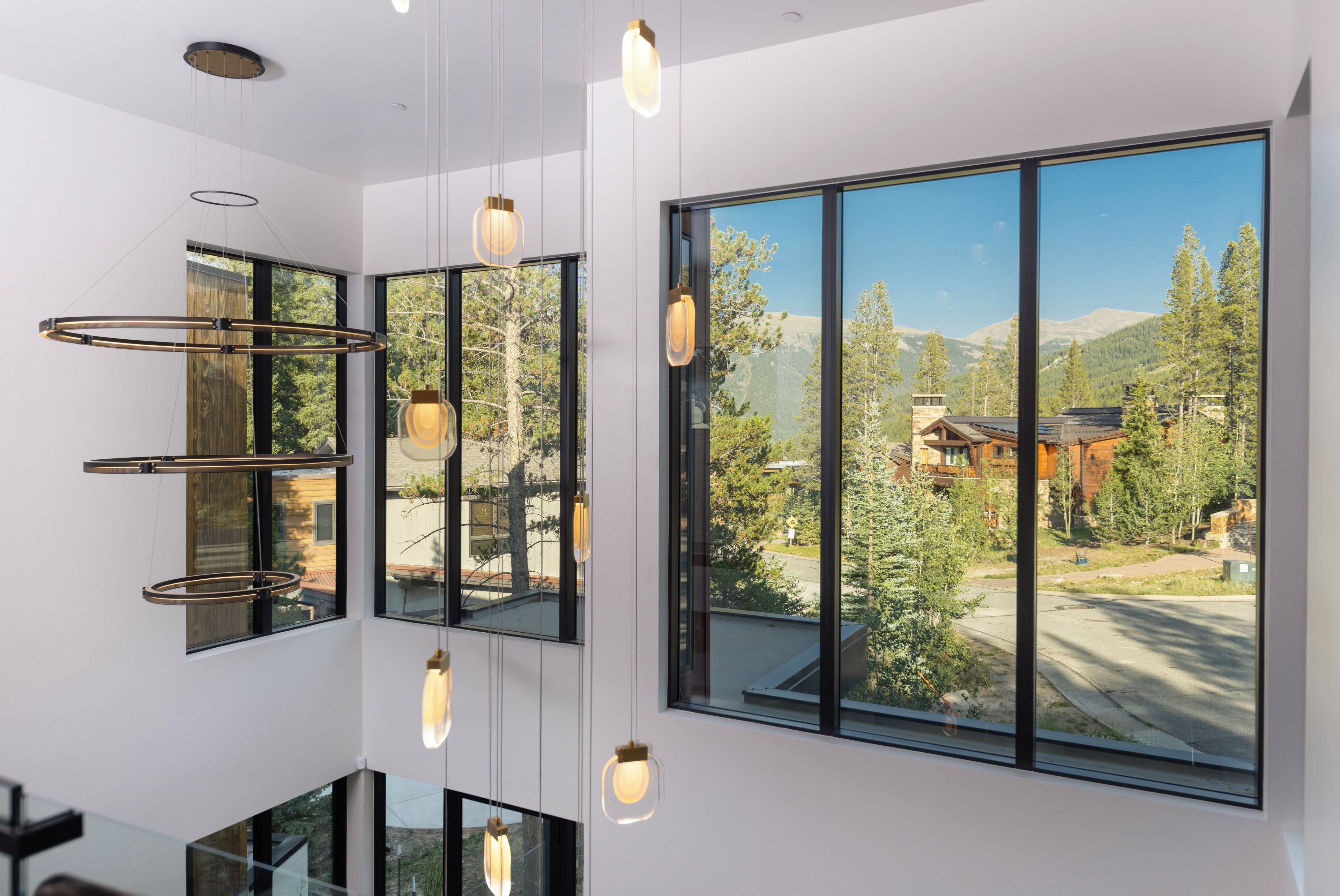 Un intérieur moderne doté de grandes fenêtres offrant une vue sur un paysage montagneux.