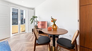A modern room with a round table, two chairs, a potted plant, a vase with flowers, and a 'GUEST READY' sign. - GuestReady - Santa Barbara Garden House 32 (Braga)