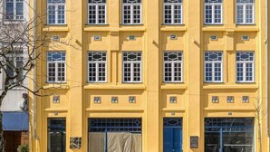 A multi-story building with a yellow facade, blue doors, and a tiled ground floor. - GuestReady - Santa Barbara Garden House 32 (Braga)