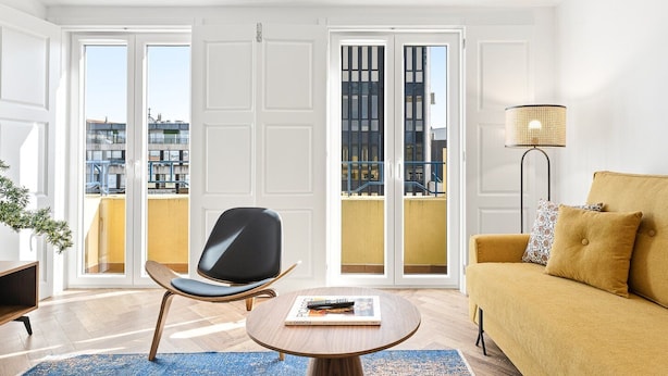Una sala de estar moderna con un sofá, una silla, una mesa de centro y una lámpara de pie.