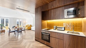 Una cocina moderna con armarios de madera, un microondas, un tostador y un lavabo.