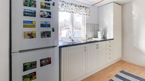 Uma cozinha com geladeira, pia e armários.