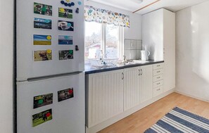 A kitchen with a refrigerator, a sink, and cabinets. - 2 bedroom lovely home in Röke (Röke)