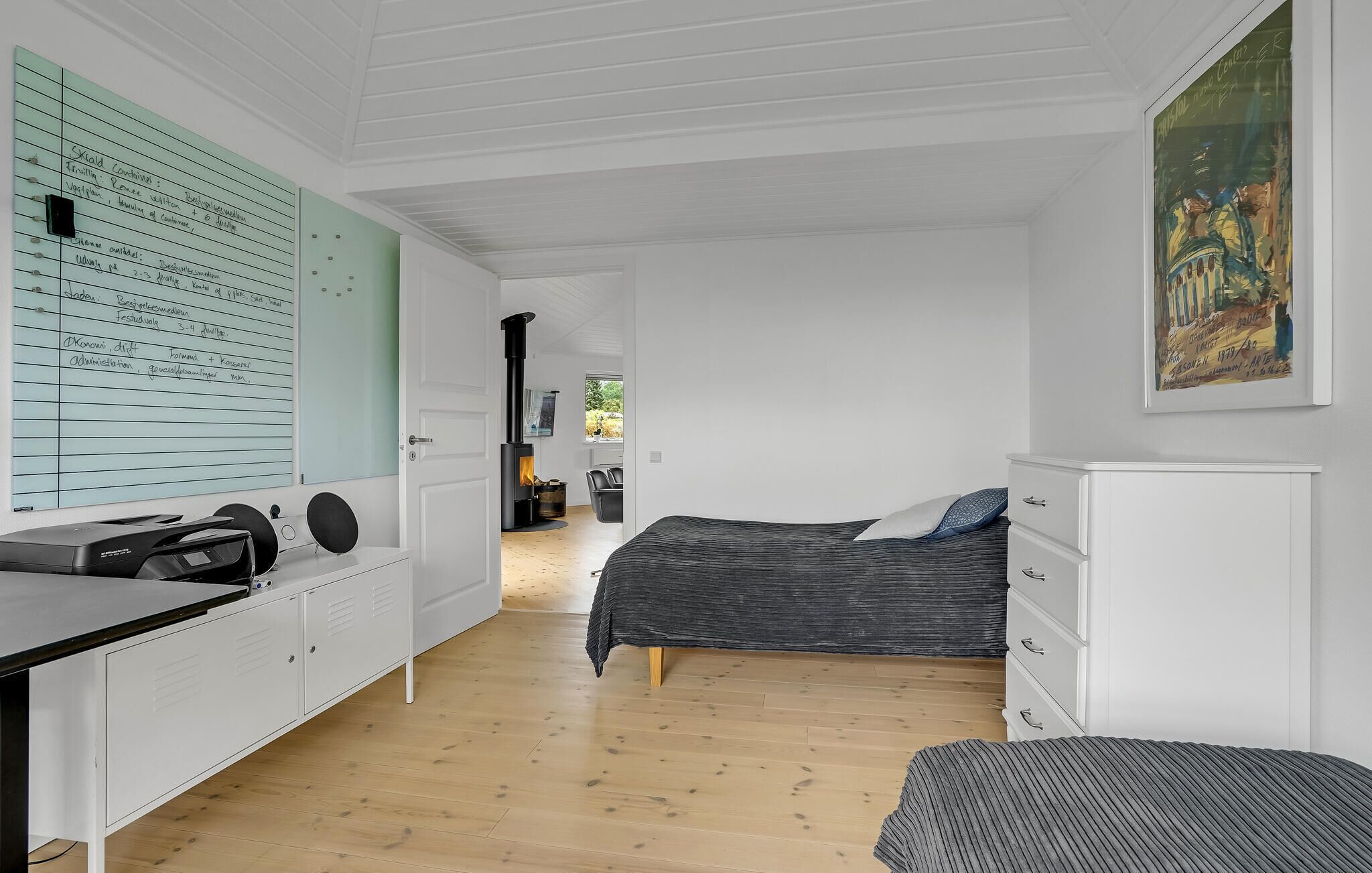A bedroom with a bed, a desk, a chair, a wardrobe, and a fireplace.