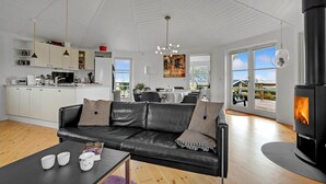 Un salon moderne avec un canapé en cuir noir, une table basse et une cheminée.