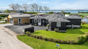 Un quartier résidentiel comprenant plusieurs maisons, une allée gravillonnée et un panneau indiquant l’adresse.