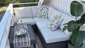 A white outdoor sofa with floral cushions, a checkered table, and a potted plant. - Awesome home in Hamburgsund with WiFi (Hamburgsund)