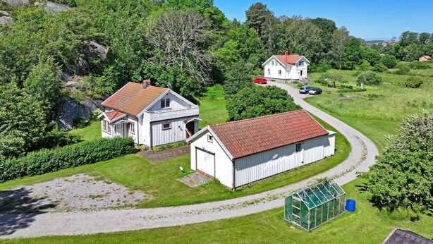 A rural property with two white buildings, a greenhouse, and a gravel driveway. - Awesome home in Hamburgsund with WiFi (Hamburgsund)