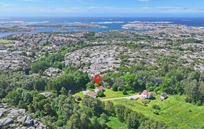 An aerial view of a coastal village with rocky terrain, green areas, and scattered houses. - Awesome home in Hamburgsund with WiFi (Hamburgsund)
