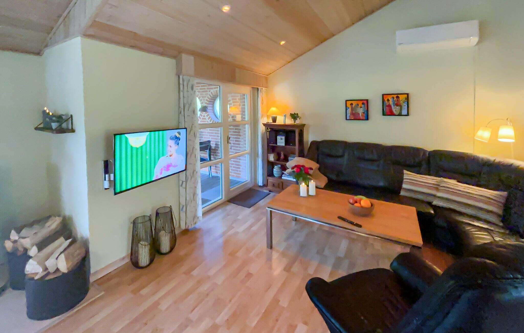 A living room with a TV, a sofa, a coffee table, and a fireplace.