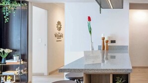 A modern kitchen with a central island, bar stools, and a variety of potted plants. - Luxury Boutique Apt | Miraflores | Ocean View (Miraflores)