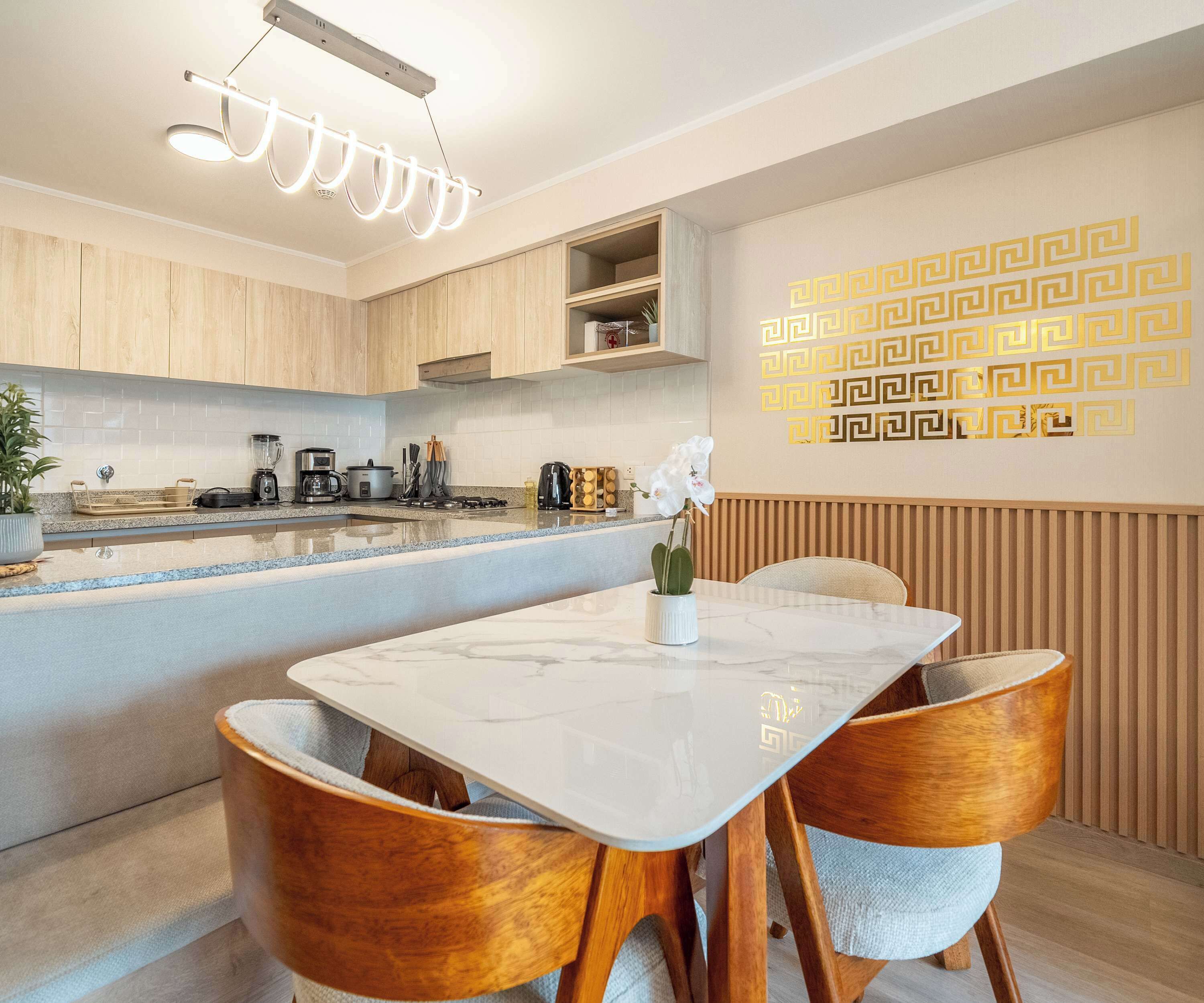 Une cuisine moderne avec des meubles en bois, un plan de travail en marbre et un four encastré.