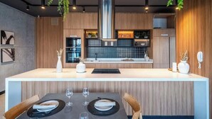 Une cuisine moderne dotée d’un îlot central, de meubles en bois et de plantes suspendues.