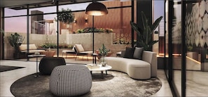 A modern living room with a sofa, armchair, ottoman, and coffee table, with large windows and plants. - Top floor apartment | The best view in miraflores (Miraflores)