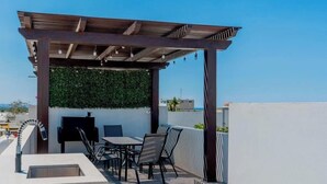 An outdoor patio with a pergola, seating, and a grill. - Pool, BBQ & a Short Walk to the Malecon (La Paz)