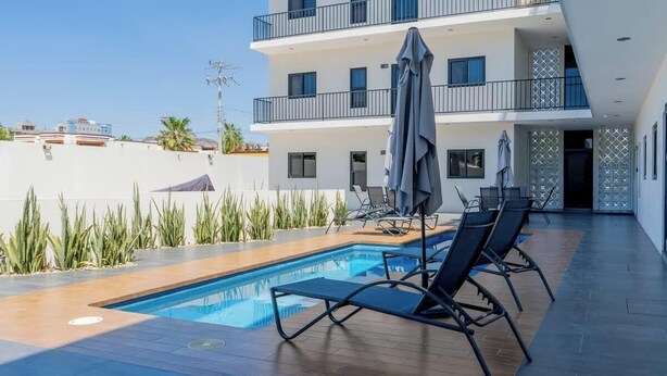 A modern hotel with a rooftop pool, outdoor seating, and a multi-story building. - Pool, BBQ & a Short Walk to the Malecon (La Paz)