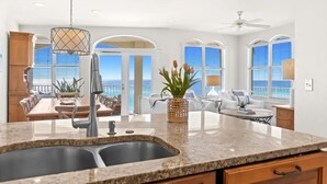 A kitchen with a granite countertop, double sink, and a dining area with a view. - Gulf Front w/ Amazing Panoramic Gulf Views! Seacrest Beach | Private Beach Access (Seacrest Beach)