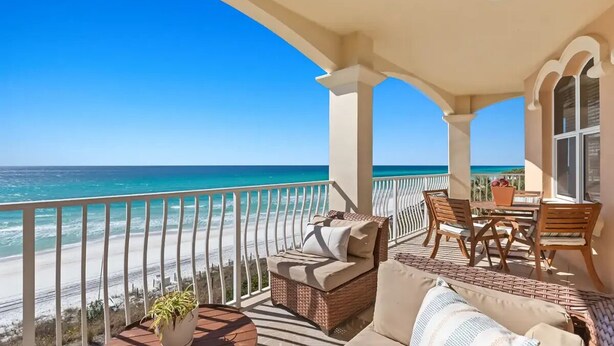 A balcony with a view of the ocean, wicker furniture, and a table with chairs. - Gulf Front w/ Amazing Panoramic Gulf Views! Seacrest Beach | Private Beach Access (Seacrest Beach)