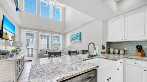 A modern kitchen with white cabinetry, a granite countertop, and a built-in dishwasher. - Awesome 4 Bedroom overlooking Pool / Easy Beach Access (Santa Rosa Beach)