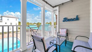A covered outdoor area with a pool, chairs, and a 'Beach' sign. - Awesome 4 Bedroom overlooking Pool / Easy Beach Access (Santa Rosa Beach)