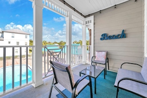 A covered outdoor area with a pool, chairs, and a 'Beach' sign. - Awesome 4 Bedroom overlooking Pool / Easy Beach Access (Santa Rosa Beach)