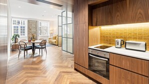 Una cucina moderna con mobili in legno, forno integrato e un piano di lavoro con bollitore e tostapane.
