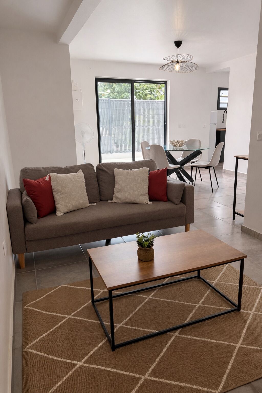 A modern living room with a sofa, coffee table, and dining area.
