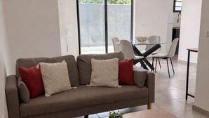 Ein modernes Wohnzimmer mit einer Couch, einem Couchtisch und einem Essbereich.