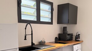 Eine moderne Küche mit eingebautem Geschirrspüler, einer Mikrowelle, einer Kaffeemaschine und einer Waschmaschine.