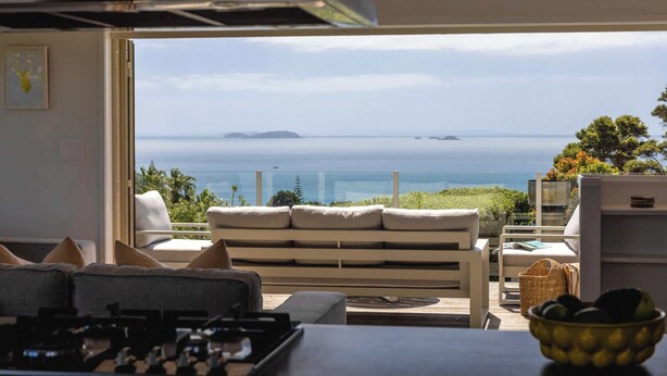 Un salon moderne avec un canapé, une table à manger et une vue sur la mer.