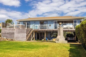 Une maison moderne à deux étages, dotée d’un balcon, d’un garage et d’un escalier menant à l’étage supérieur.