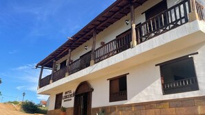 Un edificio a due piani con un balcone, un cartello con la scritta 'HOTEL LEGENDEK' e un ingresso in pietra.