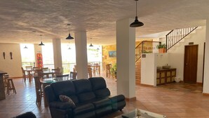 Un'ampia zona giorno con divano, tavolino e una scala che conduce a un piano superiore.