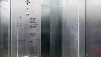En hissinredning med en panel för att välja våning, som visar våningarna 31–32, 21–24, 11–14 samt utgången.