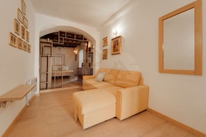 A modern living room with a sofa, a wooden bench, and a built-in shelving unit.