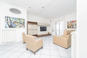 A modern living room with a sofa set, a TV, and artwork on the walls. - Atelier sul Mare exclusive property near the sea in Minori, Amalfi Coast (Minori)