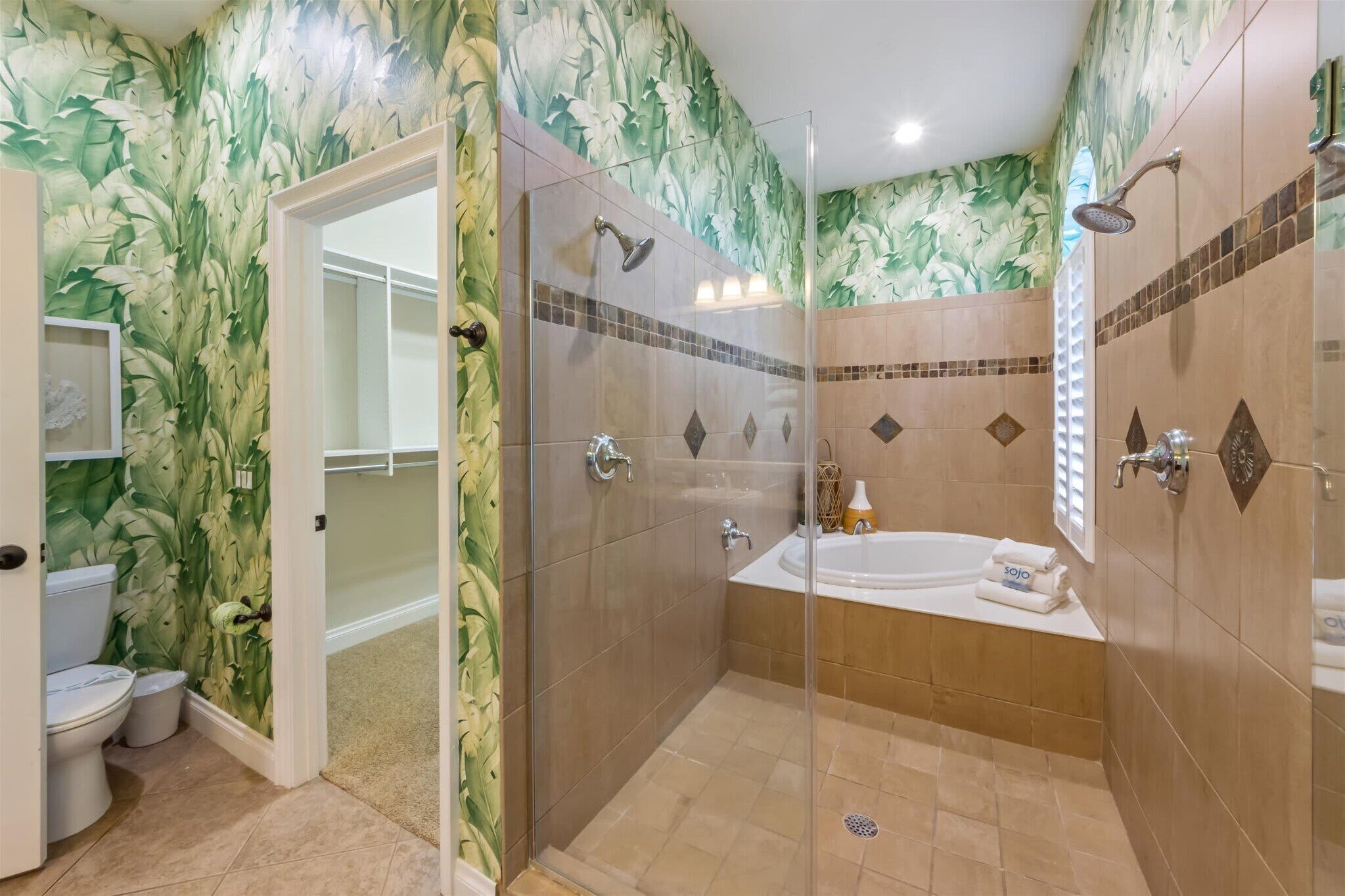 Un baño con ducha envuelta en vidrio, una bañera y un inodoro.
