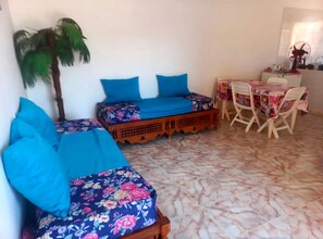 Una habitación con una cama, una mesita y una silla.