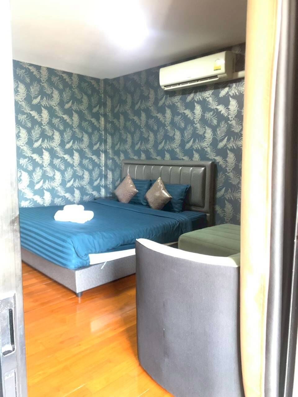 Una camera da letto con un letto, un cuscino, un comodino e un condizionatore d'aria.