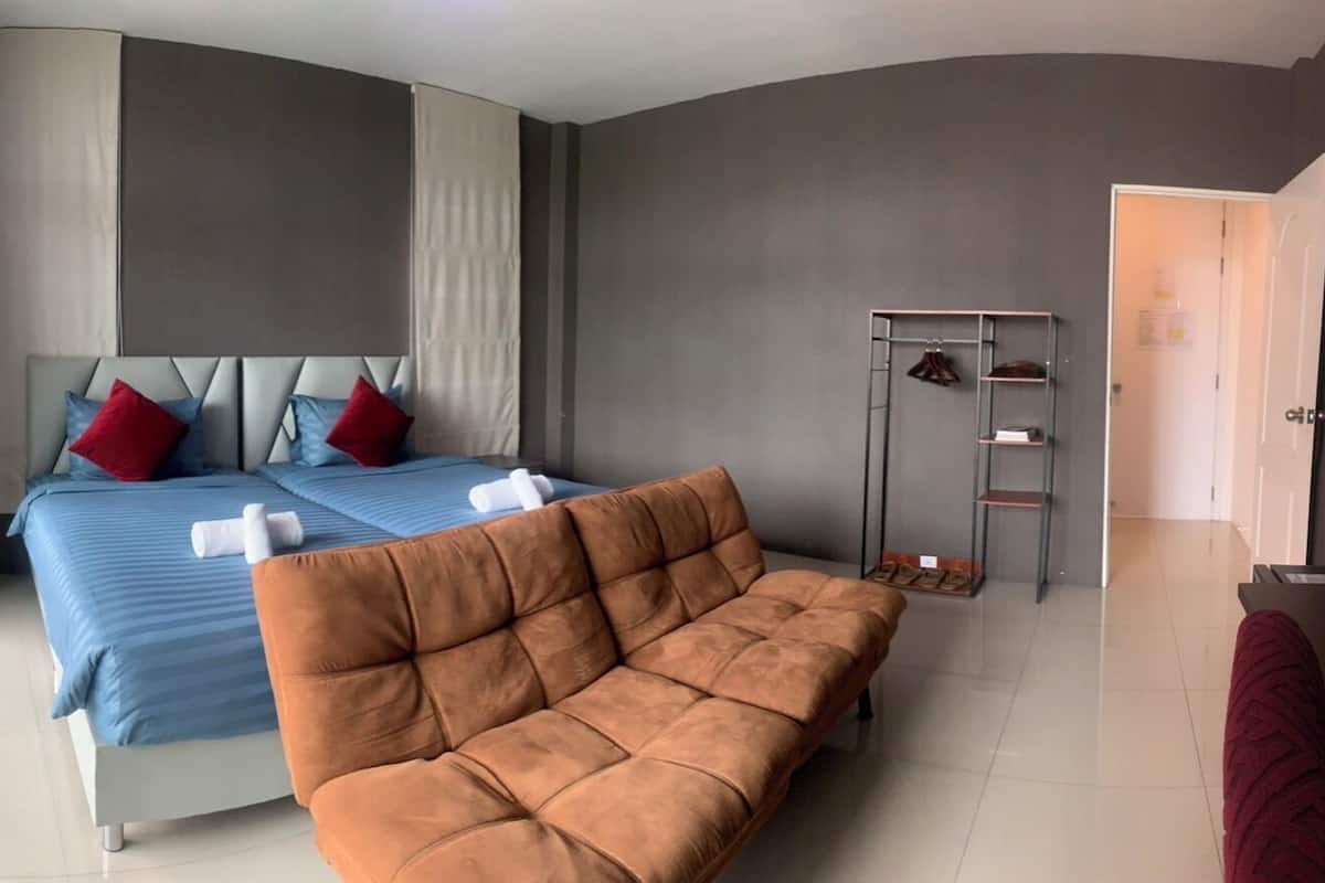 Une chambre à coucher avec un lit, un canapé, un porte-chaussures et une porte.